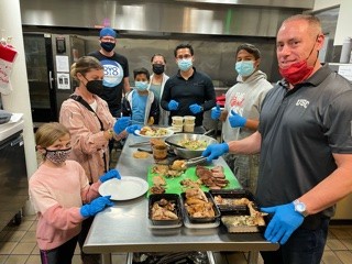 Ian King Los Angeles serving meals with volunteers in a community kitchen