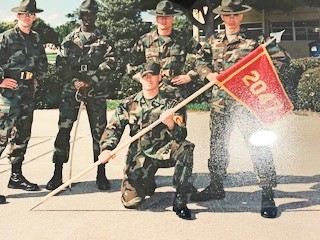 Ian King Los Angeles, a military Veteran, with fellow Marines holding a company guidon